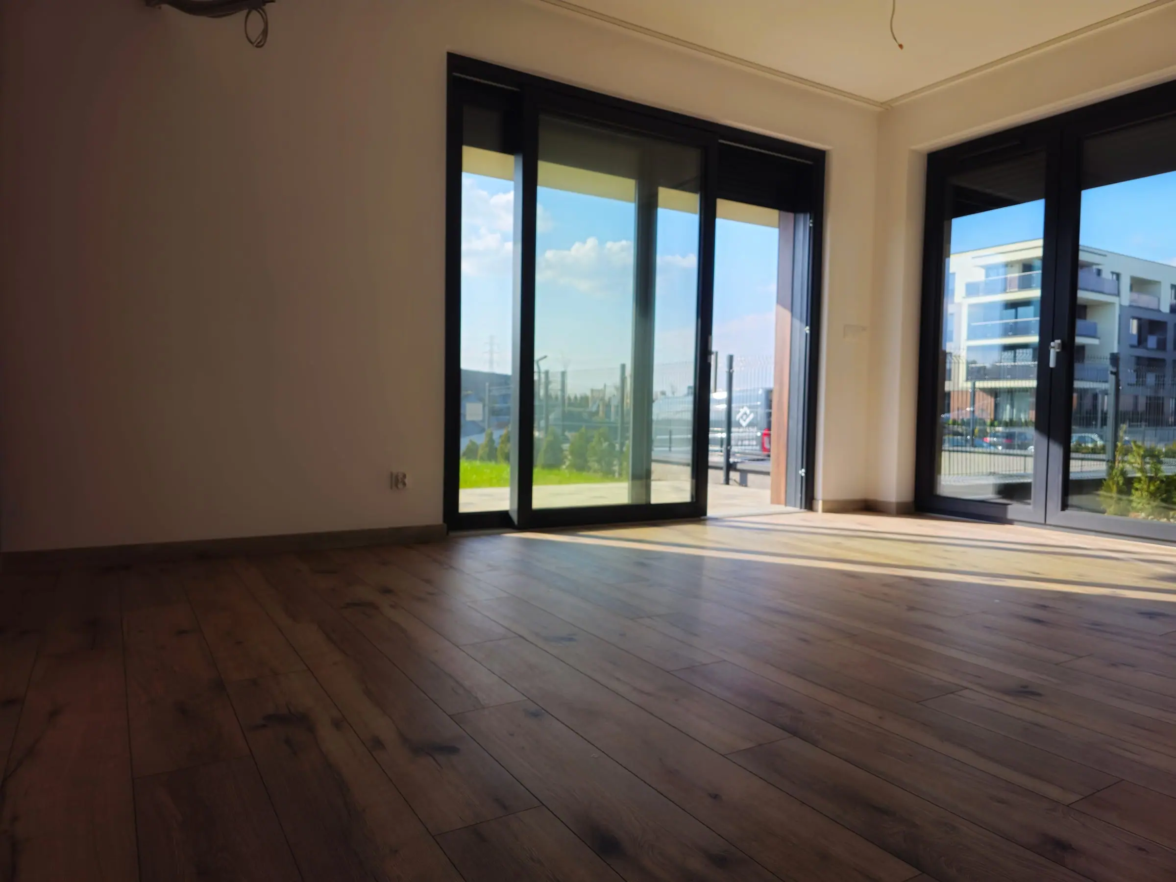 Jasny salon z dużymi przeszkleniami i dębową podłogą